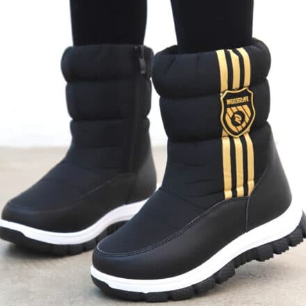 Bottes de neige pour fille noir et motif a rayures et rond de couleur doré sur un fond blanc et un sol beige