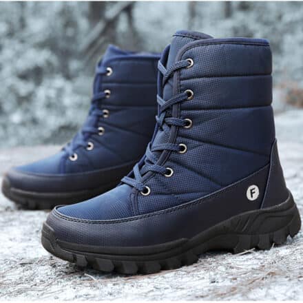 Paire de chaussures de marche bleues à lacets posées sur une pierre en extérieur