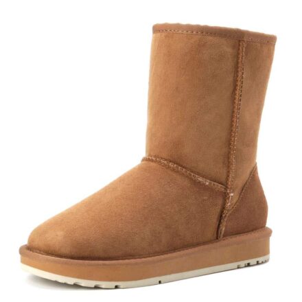 Bottes chaudes d'hiver en daim marron sur fond blanc.