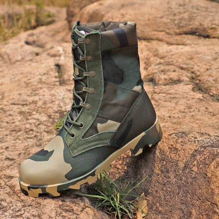 Botte verte de camouflage de chasses pour homme. La botte est posée sur des roches orangers du désert.