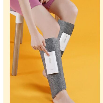 Bottes grises de massage sur jambes et sur fond jaune