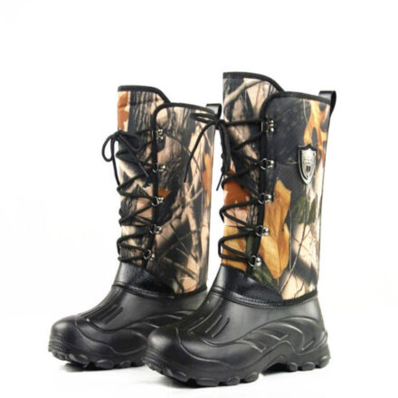 Bottes de pêcheur noires avec des lacets et un tissu motifs camouflage avec des feuilles d'automne dessus.