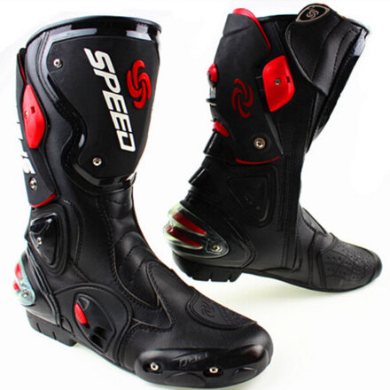 Deux bottes de moto haute pour course, noires et rouges.