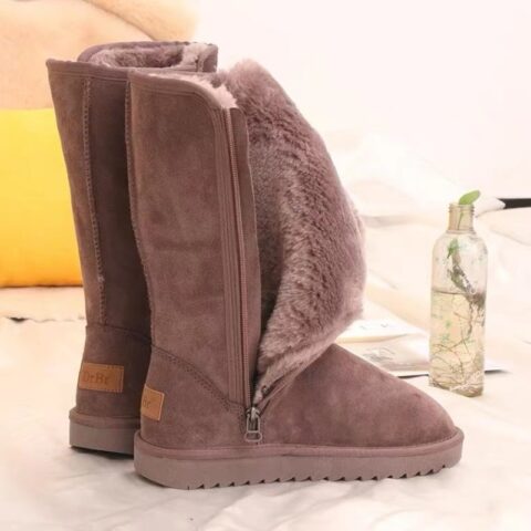 paire de botte marron montante fourré de duvet doux, posées sur un tapis blanc