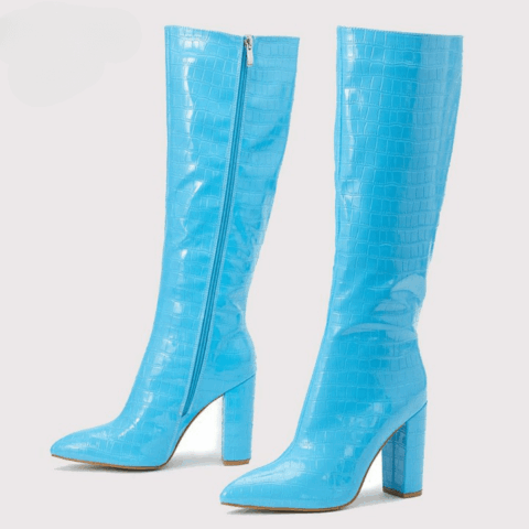 Paire de bottes hautes bleu clair, de trois-quarts vers la gauche. On voit la face interne avec la fermeture éclair de la botte en arrière-plan, et on voit la face externe de la botte en premier plan. Le tout sur fond blanc.