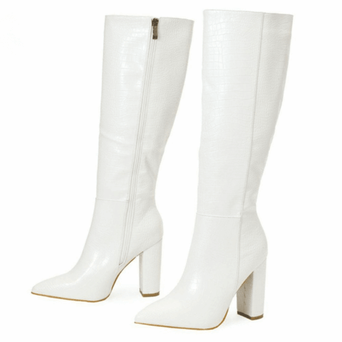 Paire de bottes hautes blanches, de trois-quarts vers la gauche. On voit la face interne avec la fermeture éclair de la botte en arrière-plan, et on voit la face externe de la botte en premier plan. Le tout sur fond blanc.