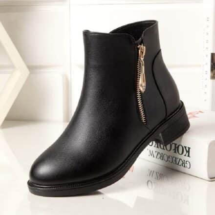 Bottes plates femme en simili cuir noires fourrées présentée sur fond blanc