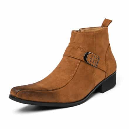 Bottine homme marron effet daim, avec bout carré et un peu noircit, et une sangle avec une boucle. Elle a un petit talon carré. De trois-quart sur fond blanc.